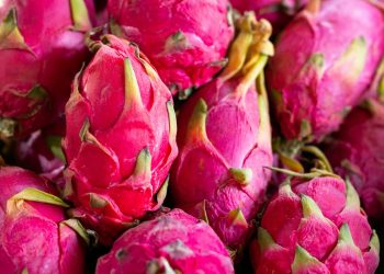 a pile of pink dragon fruit sitting on top of a table