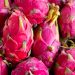 a pile of pink dragon fruit sitting on top of a table