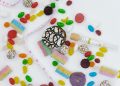Top view of assorted candies, cookies, and a tape measure symbolizing unhealthy diet choices.