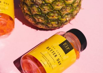 a pineapple next to a pineapple and a bottle of body lotion