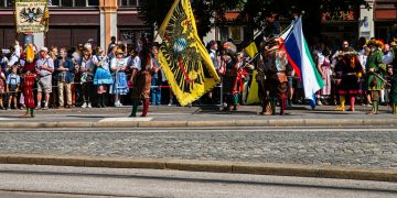a group of people standing on the side of a road