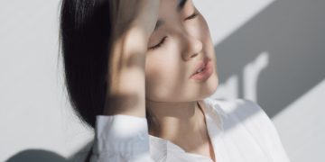 woman leaning on white table