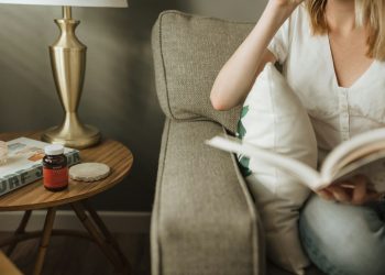 woman sitting on sofa holding book