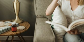 woman sitting on sofa holding book