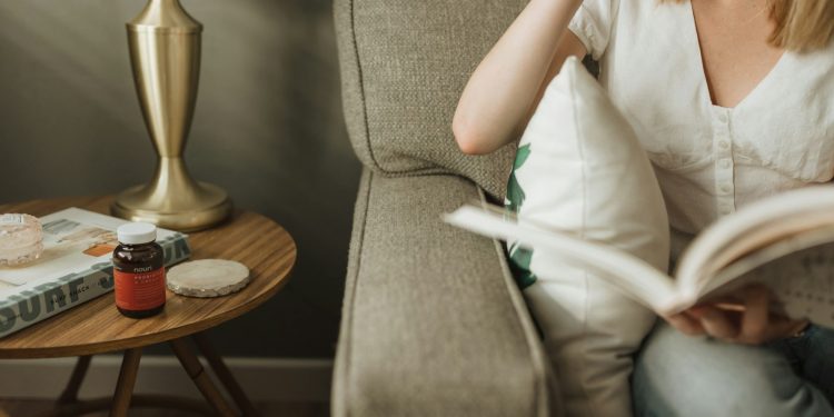 woman sitting on sofa holding book
