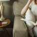 woman sitting on sofa holding book