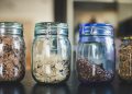 four glass jars filled with different types of food