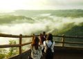 three woman standing on mountain cliff
