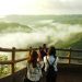 three woman standing on mountain cliff