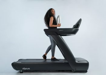a woman is walking on a treadmill