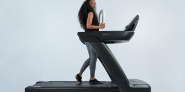 a woman is walking on a treadmill