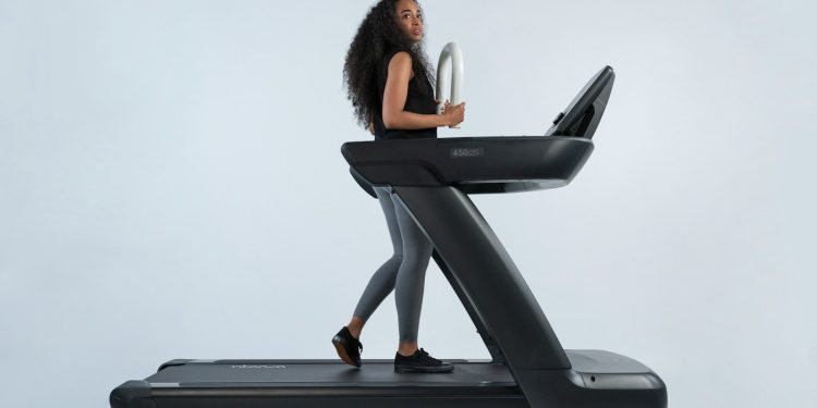 a woman is walking on a treadmill