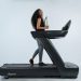 a woman is walking on a treadmill