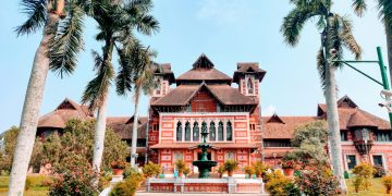 brown and white wooden house surrounded by green trees during daytime