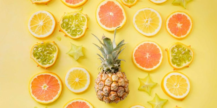 pineapple surrounded by citrus fruits