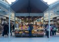 a person standing in front of a fruit stand