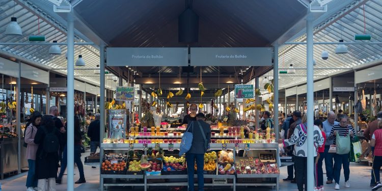 a person standing in front of a fruit stand
