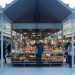 a person standing in front of a fruit stand