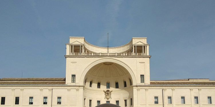 a large white building with a large metal ball in front of it