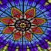 A colorful stained glass ceiling with a flower design