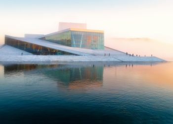 gray building near body of water under white sky