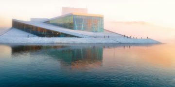 gray building near body of water under white sky