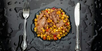 stainless steel fork and bread knife on black ceramic plate