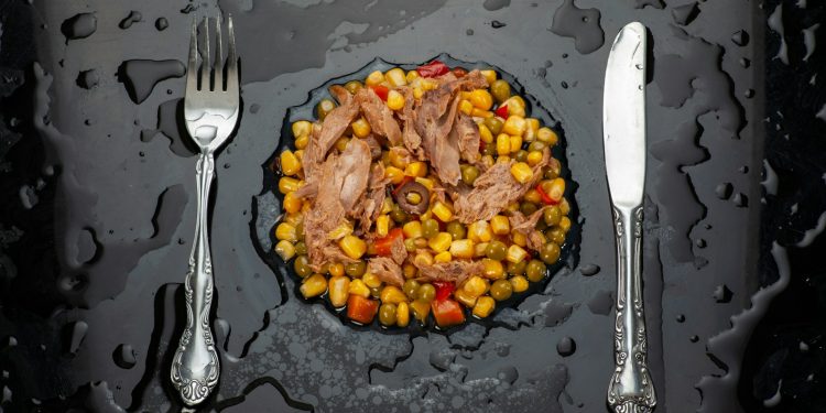 stainless steel fork and bread knife on black ceramic plate
