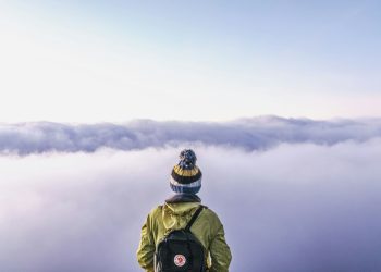 person looking thru sea of clouds