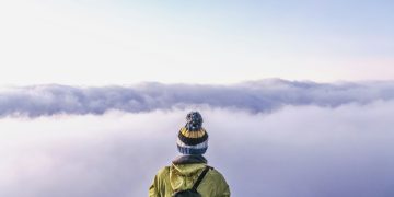 person looking thru sea of clouds