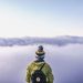 person looking thru sea of clouds