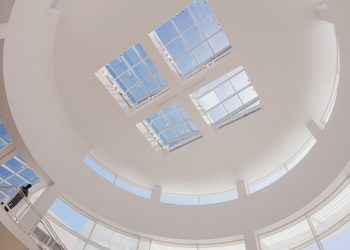 the ceiling of a large building with many windows