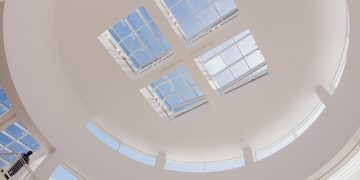 the ceiling of a large building with many windows