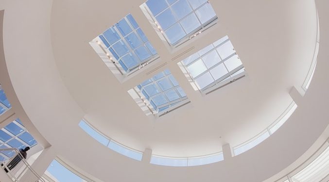 the ceiling of a large building with many windows