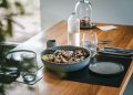 a wooden table topped with a bowl of food