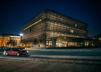 red car parked near building during night time