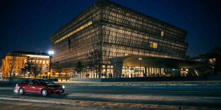 red car parked near building during night time