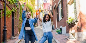 2 women standing on brown brick floor during daytime