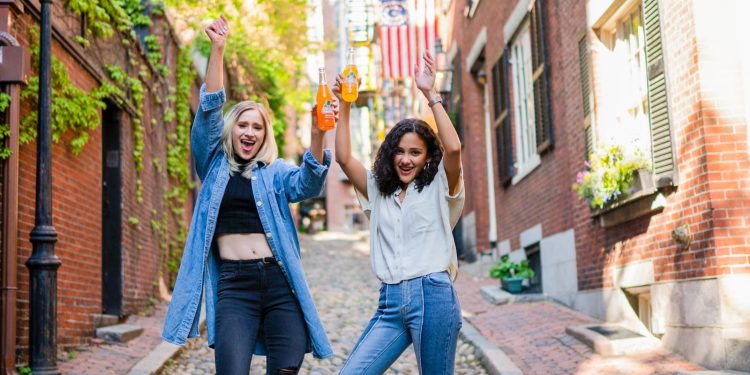 2 women standing on brown brick floor during daytime