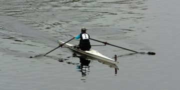 a person rowing a boat on a body of water