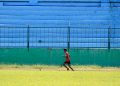 a young man running across a lush green field